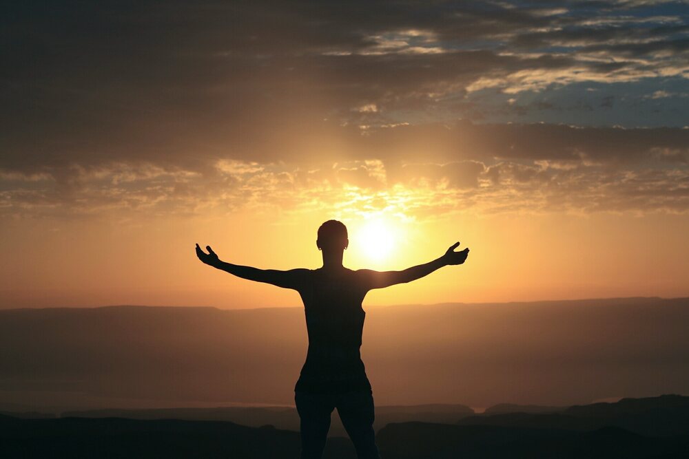 Person with arms outstretched in a display of gratitude.