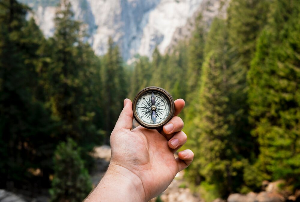 A man holds up a compass for direction