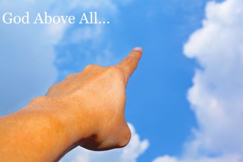 A person’s index finger points to the sky signifying the message “God above all.”