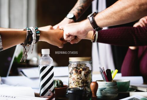 A group of people bring their hands together for a fist-bump.